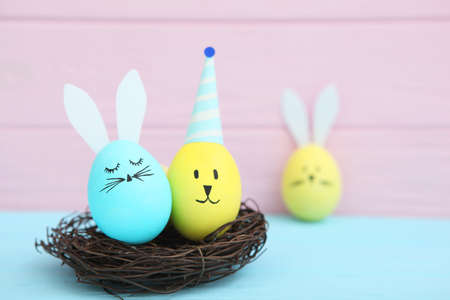 Easter eggs with cute faces and ears on a colored background.の写真素材