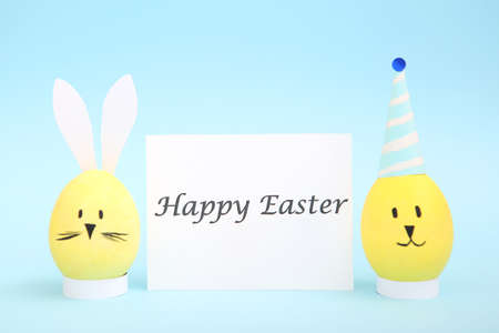 Easter eggs with cute faces and ears on a colored background.