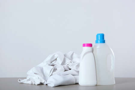 Laundry detergent bottles and clothes on the table. Household chemicalsの写真素材