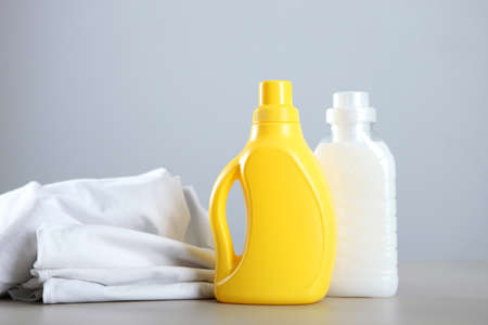 Laundry detergent bottles and clothes on the table. Household chemicals