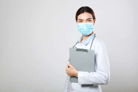 Young woman doctor on light backgroundの写真素材