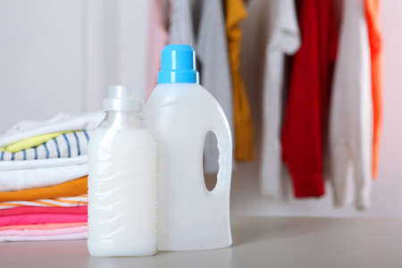 Laundry detergent bottles and clothes on the table. Household chemicalsの写真素材