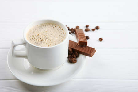 cup of coffee, coffee beans and chocolate on the table close upの写真素材