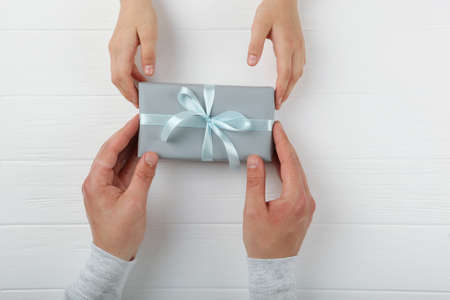 hands of a man and child holding a gift top view.の写真素材