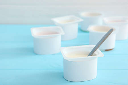 Tasty yogurt in a plastic glass on a colored table. Place to insert text.の写真素材