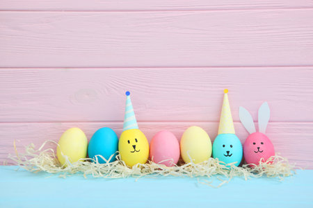 Easter eggs with cute faces and ears on a colored background.の写真素材
