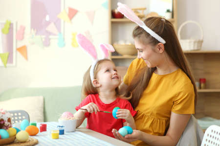 Mom and daughter paint Easter eggs for the holiday. Easter traditions.の写真素材