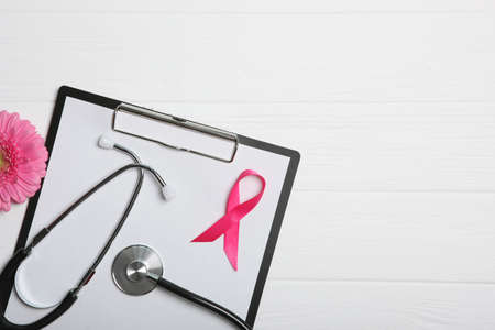pink ribbon, gerbera and stethoscope on a colored background top view.の写真素材