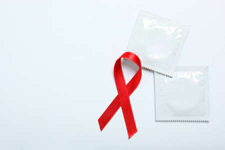Condoms and red ribbon symbolizing AIDS. World AIDS Dayの写真素材