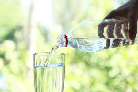 Clear water in a glass and bottle on the table