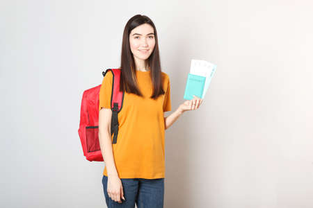 Beautiful young smiling girl holds tickets for travel. Rest, travel, tour.の写真素材