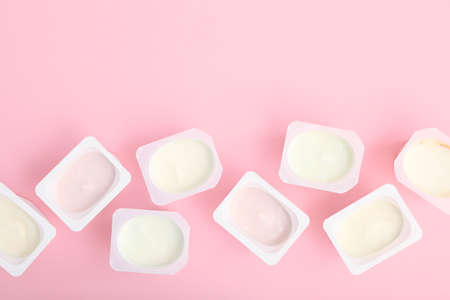 Tasty yogurt in a plastic glass on a colored table. Place to insert text.の写真素材