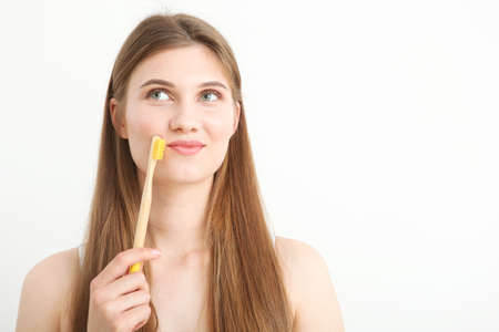 girl with a toothbrush on a light background.の写真素材