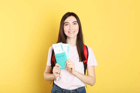 Beautiful young smiling girl holds tickets for travel. Rest, travel, tour.の写真素材