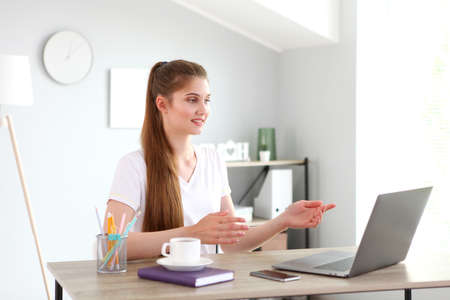 The girl works remotely from home using a modern laptop.