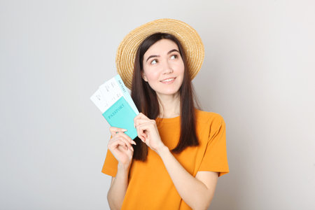 Beautiful young smiling girl holds tickets for travel. Rest, travel, tour.の写真素材