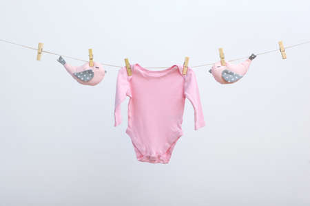 Baby clothes on a rope on a colored background.の写真素材
