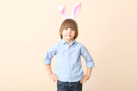 Little cute boy with Easter eggs in his hands and bunny ears on his headの写真素材
