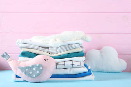 a stack of baby clothes on a light background.