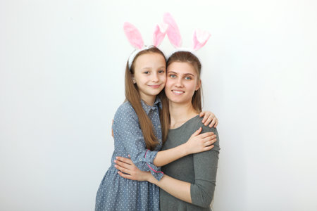 Mom and daughter with rabbit ears on a colored background.の写真素材