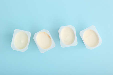 Tasty yogurt in a plastic glass on a colored table. Place to insert text.の写真素材