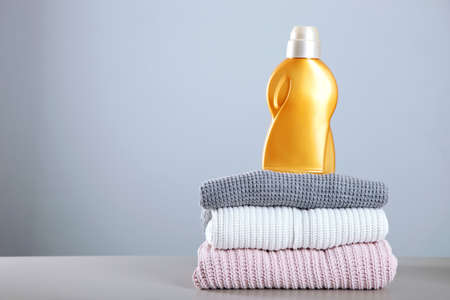 Laundry detergent bottles and clothes on the table. Household chemicalsの写真素材