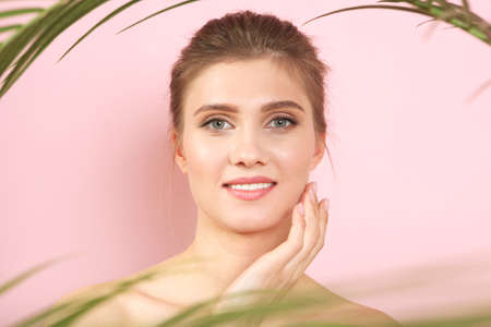 Portrait of a beautiful young girl with nude makeup on a colored backgroundの写真素材