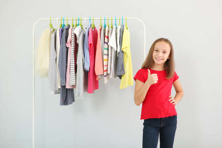 Little cute girl chooses clothes in dressing roomの写真素材
