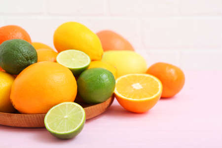 Different citrus and juicy slices on a colored background. Place to insert text.