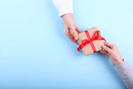 Two pairs of hands and a shot on a colored background top view