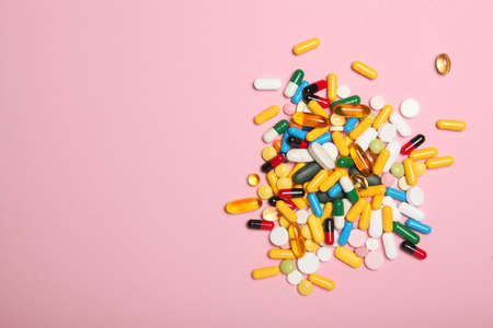 pills on a colored background top view. Medicine, treatment, illness.