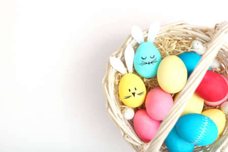 Easter eggs with cute faces and ears on a colored background.