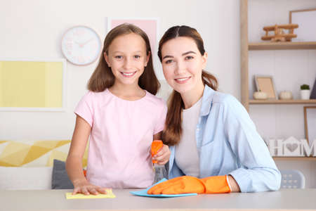 Mother and daughter in a good mood are cleaning the houseの写真素材