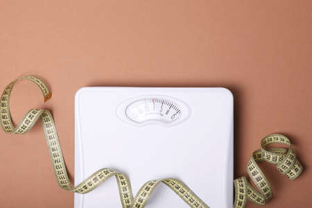 floor scales and tape measure on a colored background top view.の写真素材