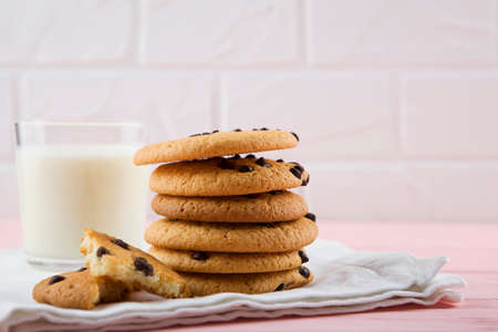 Delicious cookies with chocolate chips on a colored background