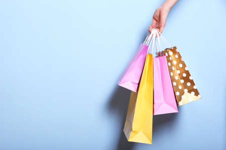 bags for shopping in hand on a colored background. Paper bags for shopping.