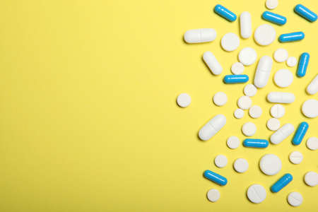 pills on a colored background top view. Medicine, treatment, illness.