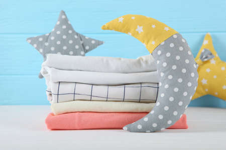 a stack of baby clothes on a light background.