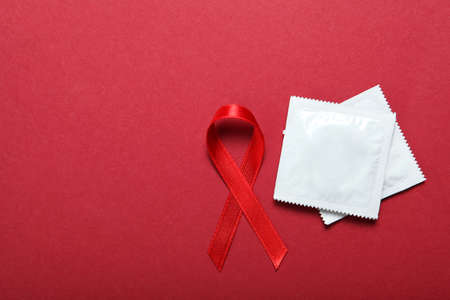 Condoms and red ribbon symbolizing AIDS. World AIDS Dayの写真素材