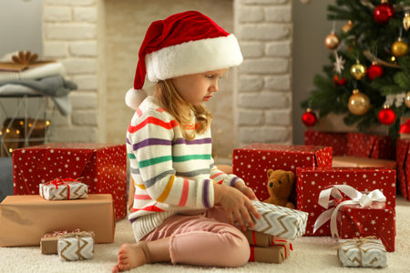 Little girl with christmas gifts in christmas interiorの写真素材