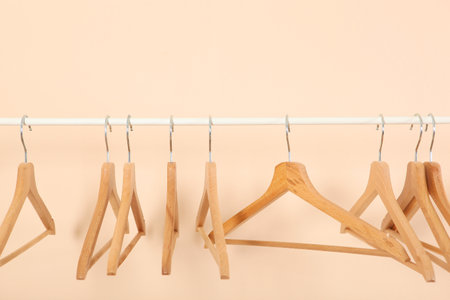 empty clothes hangers on a wardrobe rack on a colored background.の写真素材