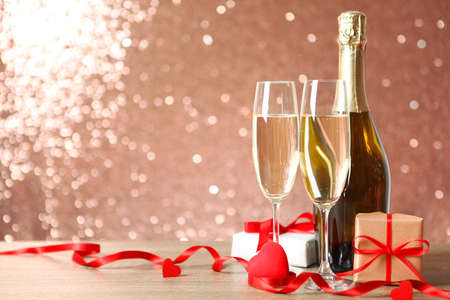 Champagne, flowers and gifts on the table. Valentines day background.の写真素材