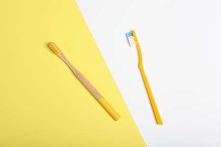 natural bamboo toothbrushes and plastic on a colored background top view.の写真素材