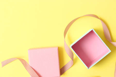 open gift box and confetti on a colored background top view.の写真素材