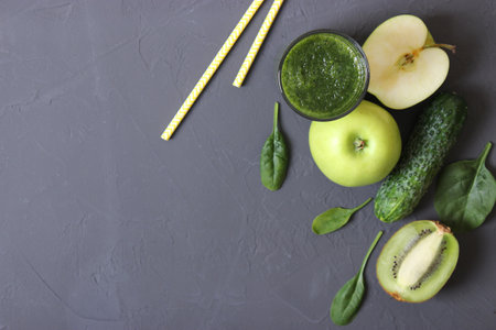 Green smoothie and fresh vegetables on the table for the detox organismの写真素材