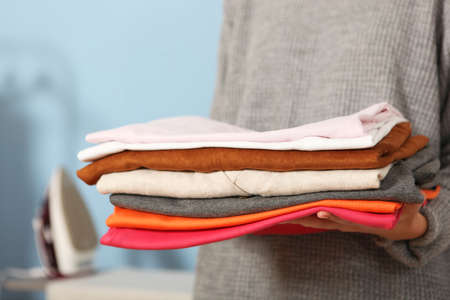 Iron and a clothes on an ironing board on a colored background.の写真素材