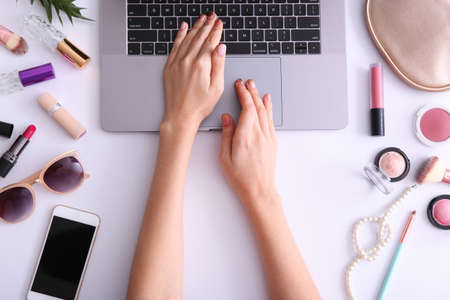 Beauty blog concept. Modern laptop and female hands, cosmetics top viewの写真素材