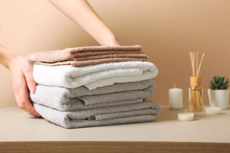 a stack of fresh towels in female hands.の写真素材