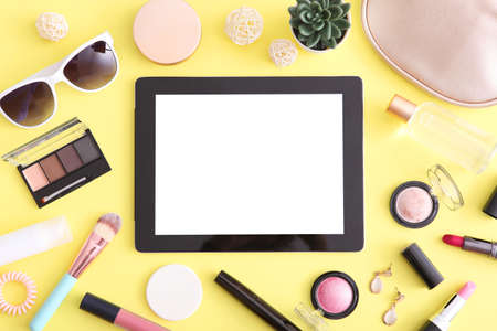 cosmetics and modern tablet on a colored background top view.の写真素材