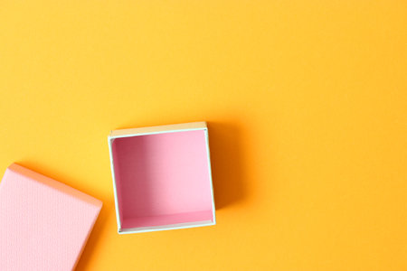 open gift box and confetti on a colored background top view.の写真素材
